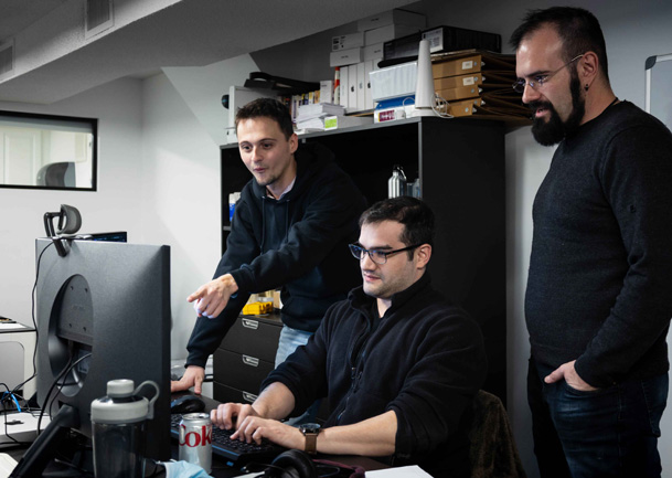 picture showing jd software developers around a computer screen