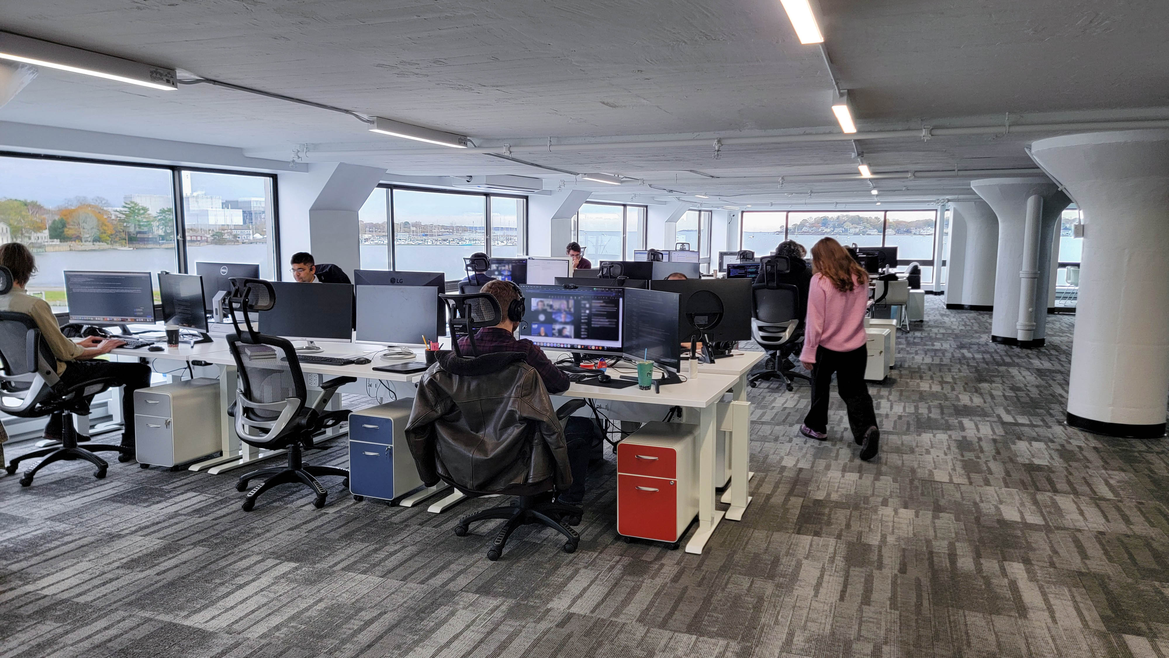 The image shows an open space office with views of Salem Harbor